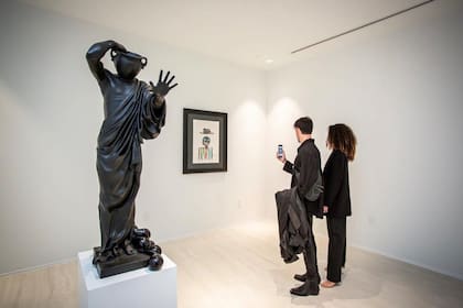 Una escultura del artista argentino Luciano Garbati junto a una obra de Jean-Michel Basquiat, en la muestra montada en el penthouse de One Thousand Museum