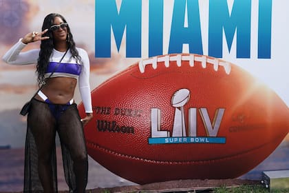 Una espectadora posa en Miami con el cartel que promociona el Super Bowl: este domingo, la gran atracción, en Miami