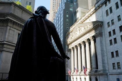 Una estatua de George Washington a un lado de la Bolsa de Valores de Nueva York (al fondo), el lunes 7 de junio de 2021.  (AP Foto/Richard Drew)