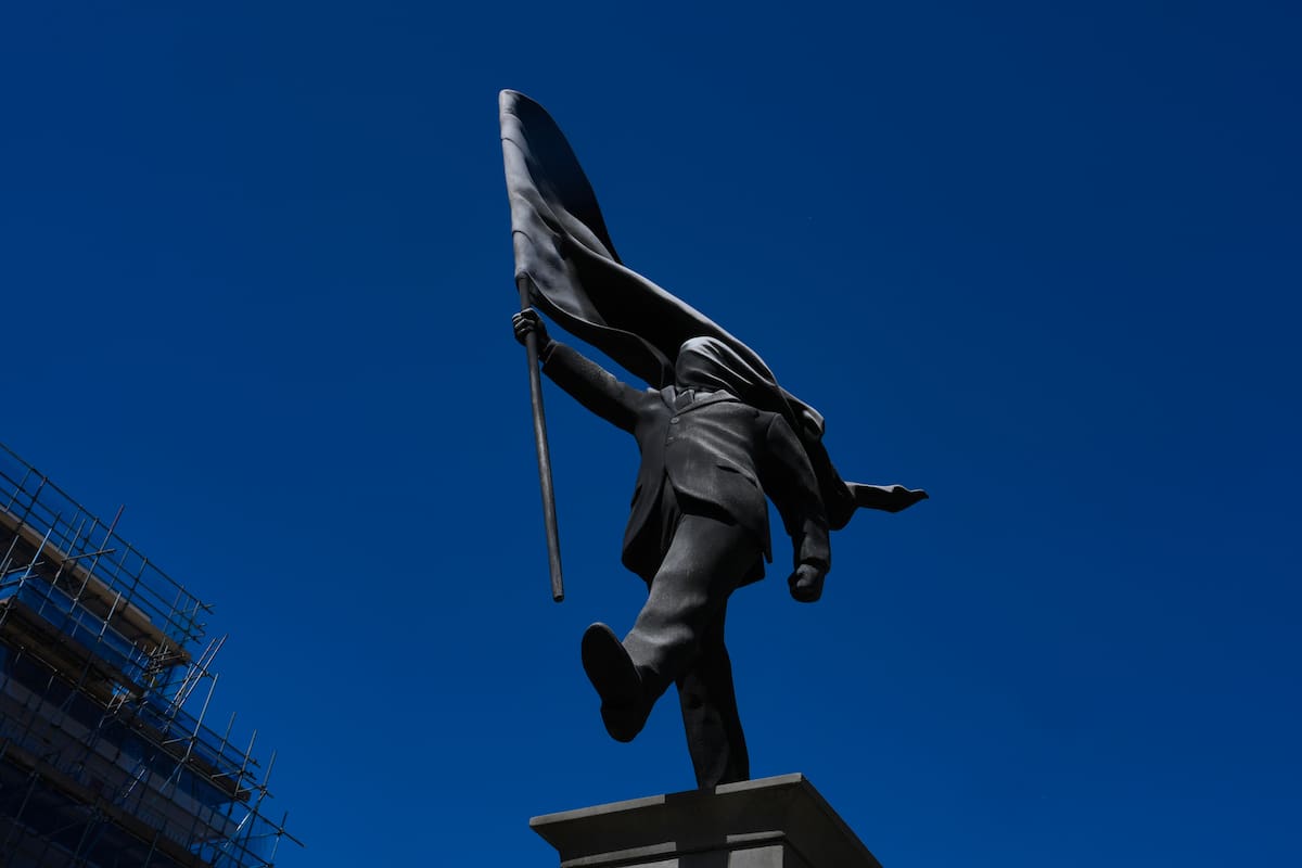 Una estatua de un hombre que sostiene una bandera que le cubre el rostro, firmada como Banksy, apareció recientemente en Londres