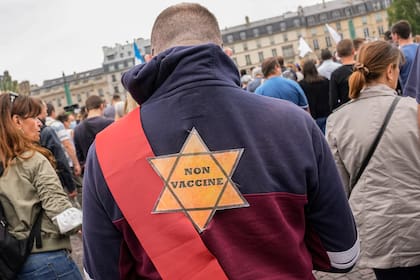 Una estrella que dice, no vacunado se adjunta en la parte posterior de un manifestante contra las vacunas durante un mitin en París