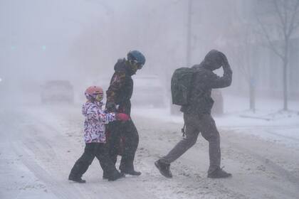Una familia cruza la Avenida Elmwood en Buffalo, Nueva York, una de las áreas más afectadas por Elliot (Foto, Derek Gee/The Buffalo News vía AP)
