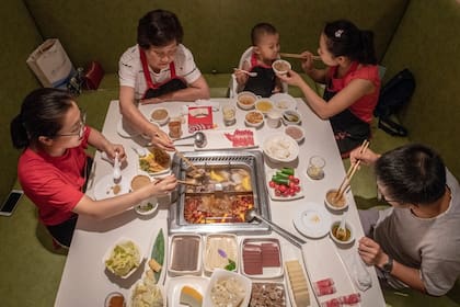Una familia en un restaurant de Beijing. Se estima que el crecimiento poblacional en China se contraiga este siglo