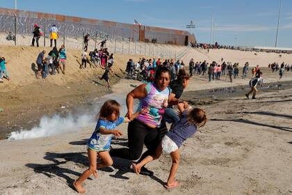Una familia escapa de los gases en la frontera entre México y EE.UU.