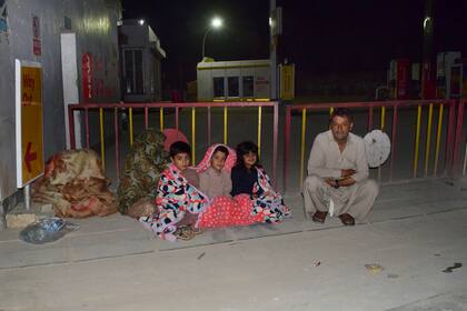 Una familia fuera de su casa tras el severo terremoto que afectó al sur de Pakistán.