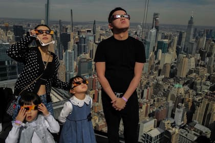 Una familia observa el eclipse en un puesto de observación, en Nueva York