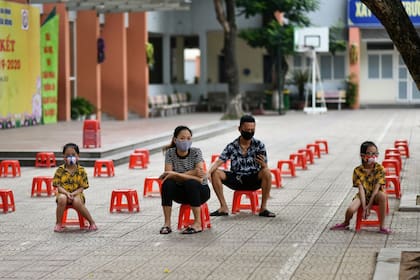 Una familia vietnamita espera para realizarse un test de covid-19, en Hanoi
