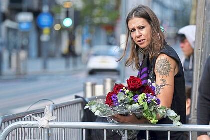 Una fan se acerca al puente de Black Sabbath para dejar un arreglo floral