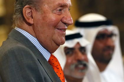 Una foto de archivo tomada el 14 de abril de 2014 muestra al ex rey de España, Juan Carlos, saludando a los funcionarios de los EAU cuando llega a una sesión del primer Foro Económico EAU-España en el hotel Emirates Palace en Abu Dhabi