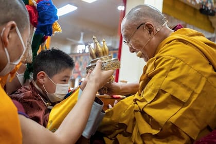 Una foto sin fecha facilitada por la oficina del Dalai Lama muestra al Dalai Lama presentando a A. Altannar, el niño mongol de ocho años que ha sido seleccionado como una de las figuras más veneradas del budismo tibetano, en una ceremonia ante fieles en marzo de 2023.