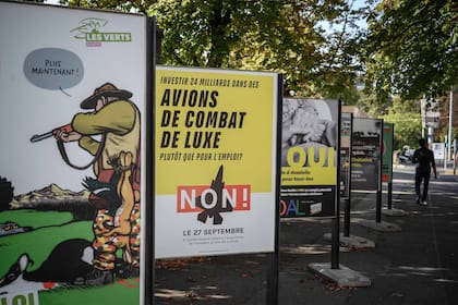Una foto tomada el 18 de septiembre de 2020 en Ginebra muestra carteles electorales sobre la reforma de la ley de caza y aviones de combate, temas que se se votarán en el referéndum del domingo