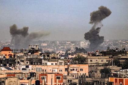 Una fotografía tomada desde Rafah, en el sur de la Franja de Gaza, muestra humo elevándose sobre los edificios en Khan Yunis durante el bombardeo israelí el 2 de febrero de 2024, mientras continúan los combates entre Israel y el grupo palestino Hamas. (Photo by SAID KHATIB / AFP)