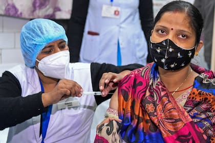 Una funcionaria de salud y una voluntaria participan en un simulacro de entrega de la vacuna contra el coronavirus en un centro de salud en Nueva Delhi, la India, el 2 de enero de 2021