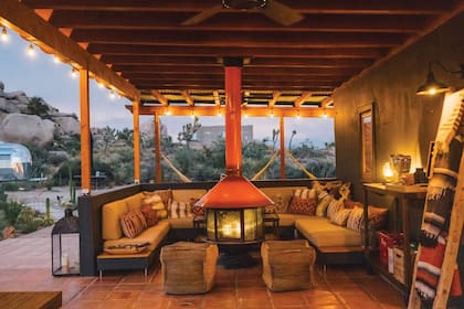 Una galería con un sillón en forma de “U” y una chimenea Malm Imperial Carousel como punto de encuentro. La propiedad también cuenta con un moderno autocine y camas exteriores para descansar en la tranquilidad del desierto