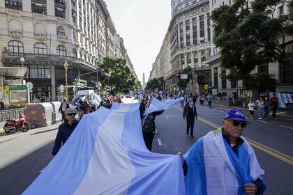 Una gran bandera es transportada por la avenida Diagonal Norte