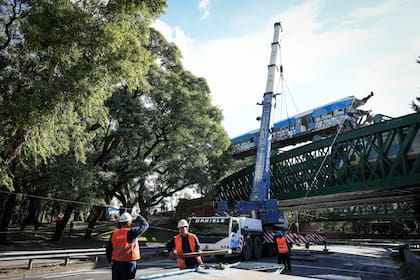 Una grúa de gran porte retira el vagón chocado, en las vías del tren San Martín