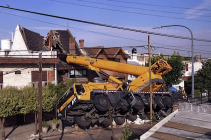 Una grúa que intentaba pasar una pileta de natación por arriba de una casa, cayó sobre la vivienda y la partió al medio
