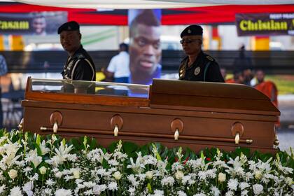 Una guardia militar hace honores junto al ataud con los restos del exfutbolista de Ghana Christian Atsu en su funeral el 17 de marzo del 2023 en Accra, Ghana. (AP Foto/Misper Apawu)