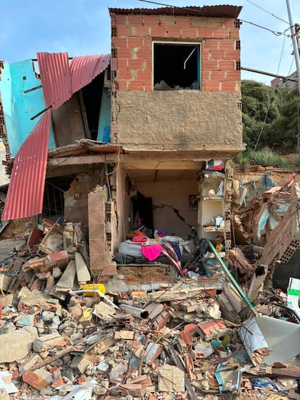 Una habitación expuesta sin pared en medio de la vivienda desmoronada