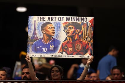 Una hincha muestra un póster relativo al enfrentamiento entre Kylian Mbappé y Lamine Yamal