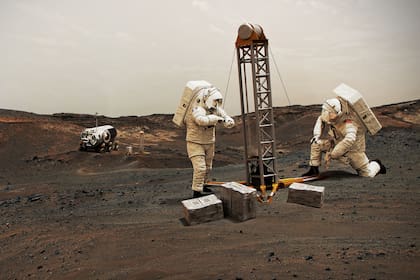 Una ilustración de la NASA imagina astronautas en suelo marciano construyendo una base; para lograrlo será necesaria maquinaria capaz de generar oxígeno, clave para las presencias permanentes en el planeta rojo