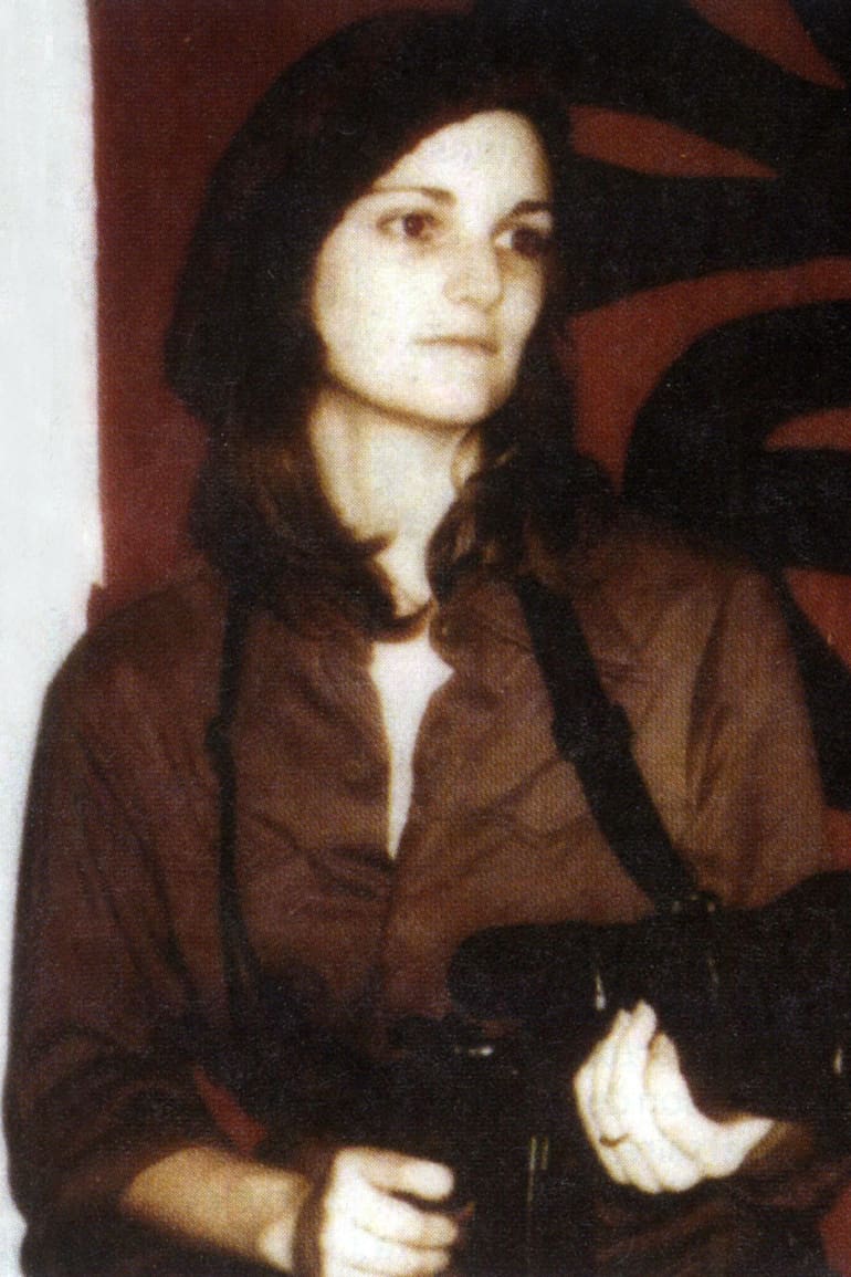 Una imagen de 1974. Patricia Hearst, con un arma en sus manos, frente a una bandera del SLA (Symbonese Liberation Army)