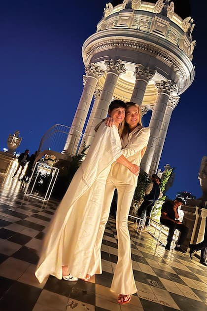Una imagen de la novia y Carla Pereyra, con la pérgola donde se realizó la ceremonia de fondo.