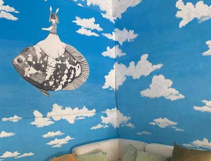 Una imagen de las paredes del cuarto de su bebé en camino, pintada con nubes y un pez volador.