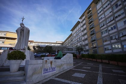 Una imagen de León XIV al pie de la estatua de Juan Pablo II en el hospital Gemelli