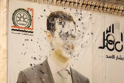 Una imagen del presidente sirio, Bashar Assad, marcada por disparos, en la oficina del gobierno provincial tras la toma de Hama por parte de la oposición, en Siria