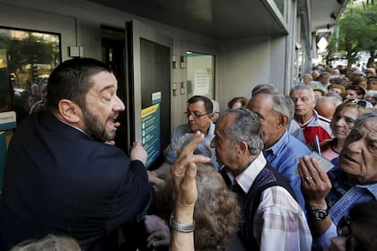 Una imagen en la puerta de un banco ayer, en Grecia, que evoca a la crisis argentina