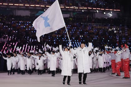 Una imagen para el mundo: atletas de las dos Corea desfilan juntos, con una bandera de la silueta de la península coreana