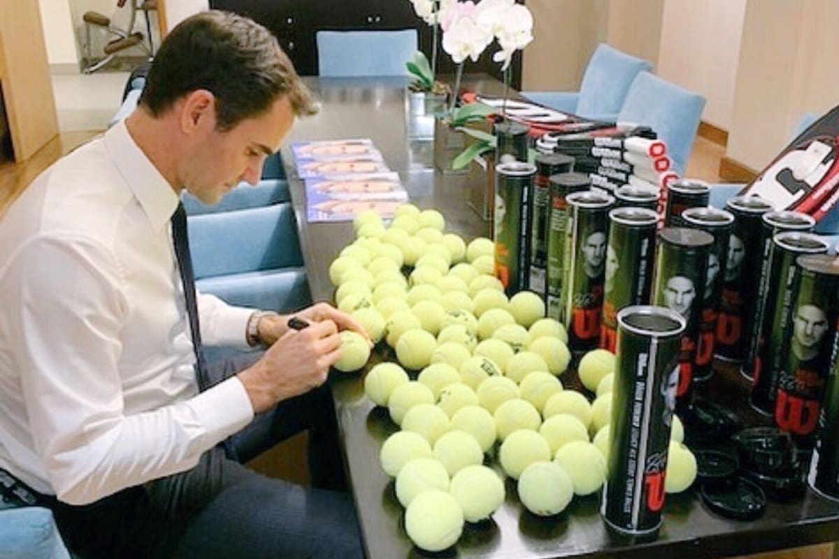 Una imagen que ilustra el compromiso de Federer con sus fans: en la noche de Buenos Aires, firmando centenares de autógrafos en objetos que luego serán obsequiados.
