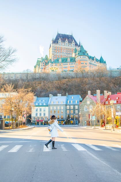 Una joven cruza la carretera frente al Hotel Chateau Frontenac explorando la ciudad de Quebec en invierno; Canadá ocupa el cuarto lugar entre los países con mejor calidad de vida