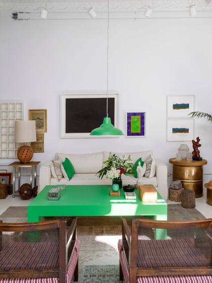 Una lámpara galponera y una mesa rústica cobran potencia de la mano del color y se integran por contraste a otros objetos refinados de estilo oriental