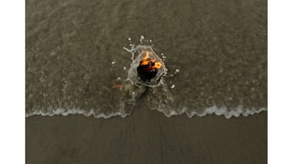 Una lámpara iluminada por un peregrino hindú se ve en la confluencia del río Ganges y la bahía de Bengala, en la isla Sagar, al sur de Kolkata