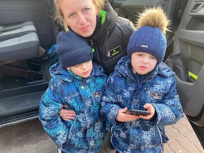 Una madre ucraniana abraza a sus hijos. Están por viajar rumbo a Valencia