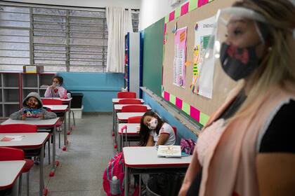 Una maestra trabaja con los estudiantes durante el primer día de regreso a clases presenciales en medio de la pandemia de Covid-19 en la escuela pública Raúl Antonio Fragoso en San Pablo, Brasil, el lunes 8 de febrero de 2021
