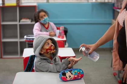 Una maestra trabaja con los estudiantes durante el primer día de regreso a clases presenciales en medio de la pandemia de Covid-19 en la escuela pública Raúl Antonio Fragoso en San Pablo, Brasil, el lunes 8 de febrero de 2021