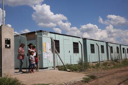 Una mamá sale con sus hijos de la escuela
