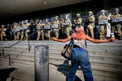 Una manifestante confronta a agentes de la Guardia Nacional en California que protegen un edificio federal en el centro de Los Ángeles, el lunes 9 de junio de 2025. (AP Foto/Eric Thayer)
