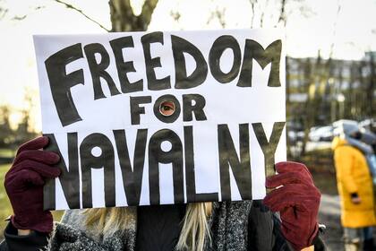 Una manifestante que exige la liberación del líder de la oposición rusa detenido Alexei Navalny sostiene un cartel frente a la embajada rusa en Estocolmo, Suecia, el 23 de enero de 2021