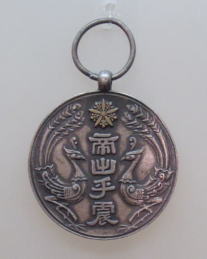 Una medalla conmemorativa de la entronización de Puyi alentada por los ocupadores japoneses.