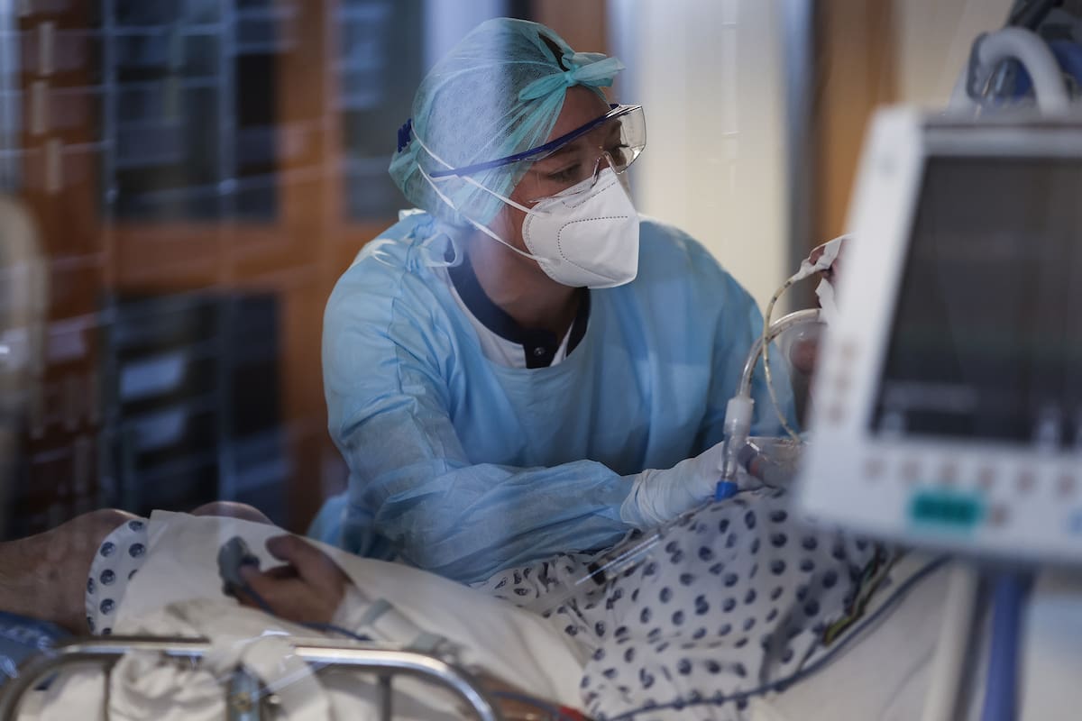 Una médica atiende a un paciente en la unidad de cuidados intensivos para pacientes infectados con coronavirus en el Centro Hospitalario Universitario de Lieja, el 22 de octubre de 2020