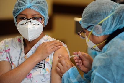 Una médica recibe una dosis de la vacuna rusa Sputnik V contra la enfermedad del nuevo coronavirus, en el Hospital Cotahuma de La Paz, Bolivia, el 3 de febrero de 2021
