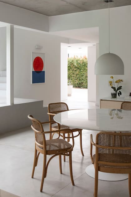 Una mesa de estilo ‘Tulip’ con tapa de mármol Calacatta y sillas ‘Thonet’.