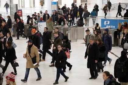 Una muchedumbre se apresta a tomar el tren PATH en el World Trade Center de Nueva York el 18 de noviembre del 2019. Mucha gente se está replanteando su vida tras la pandemia del coronavirus, dejando sus trabajos y tomando nuevos rumbos. (AP Photo/Mark Lennihan, File)