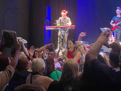 Una mujer abraza a Leda mientras le canta al público