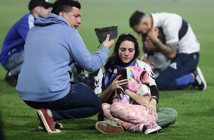 Una mujer asiste a su hija mientras trata de ubicar por teléfono a sus familiares