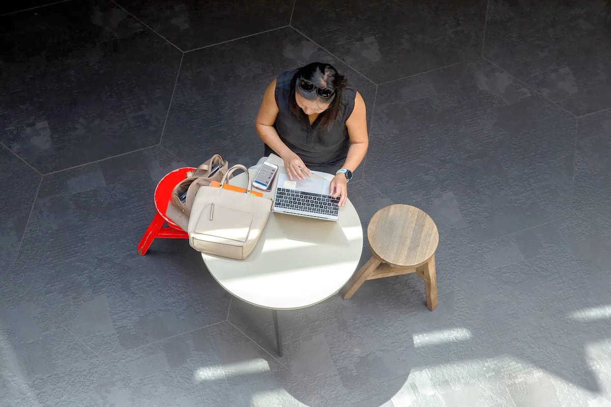Una mujer atiende el teléfono y utiliza un notebook en una cafetería de Sídney, Australia, el último país que acaba de incorporar el derecho a la desconexión digital